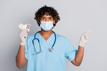 Photo of doc guy hold pills indicate empty space isolated grey color background