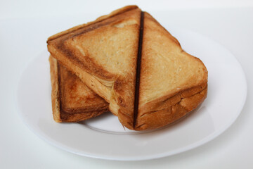 Some toasts or toasted breads, on white plate, isolated on white background