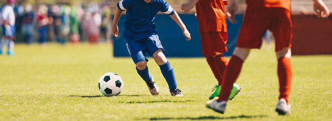 School soccer league. Kids in red and blue soccer shirts play competition match during youth football tournament