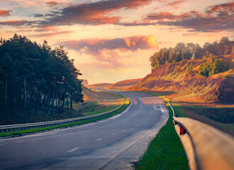 Empty asphalt road after the rain at sunrise. Picturesque summer scene of misty countryside, Ternopil location, Ukraine, Europe. Traveling concept background.