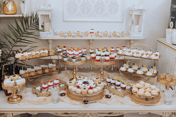 A table with a variety of desserts, including cupcakes and cakes, is set up for a party
