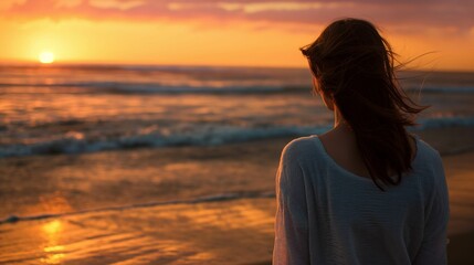 Fototapeta premium Woman watching sunset at the beach, a serene evening seascape.