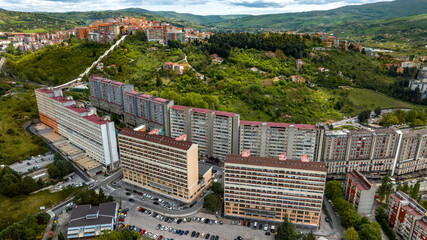 Aerial view of apartment complex known as "il Serpentone" (the great snake) due to its length. In background is the historic center of Potenza, Basilicata, Italy.