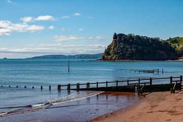 Seaside cliffs , taken from the beach with a sand groyne in the foreground. sunny day, blue sky.