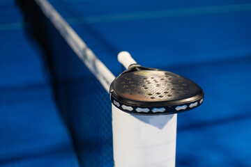 Paddle tennis: Paddel racket and ball in front of an outdoor court