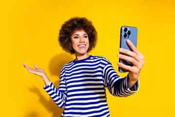 Photo of nice young girl take selfie show empty space wear striped shirt isolated on yellow color...