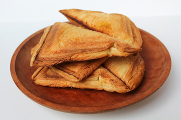 Some toasts or toasted breads, or toasted loaf, on wooden plate, isolated on white background