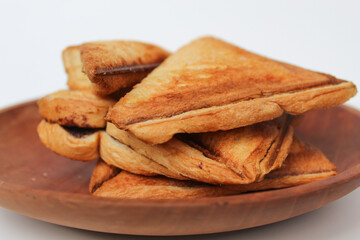 Some toasts or toasted breads, or toasted loaf, on wooden plate, isolated on white background