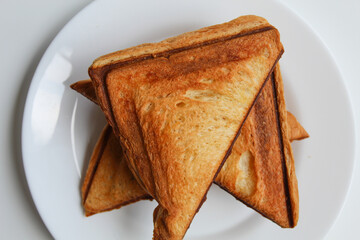 Some toasts or toasted breads, on white plate, isolated on white background, flat lay or top view