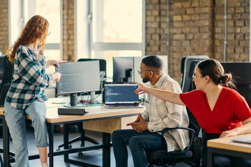Fototapeta premium A diverse group of young business individuals congregates in a modern startup coworking center, embodying collaborative innovation and a dynamic atmosphere