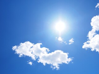 Beautiful bright blue sky with the sun shining and a few clouds on a clear sunny day