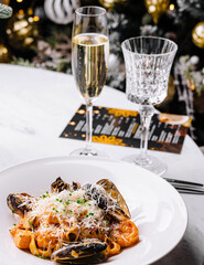 Elegant seafood pasta dish with champagne on festive table