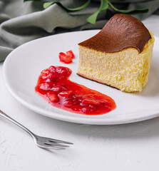 Obraz premium Delectable san sebastian cheesecake slice with strawberry sauce