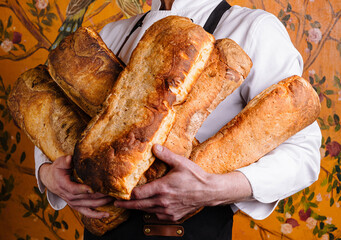 Artisan baker holding freshly baked bread loaves