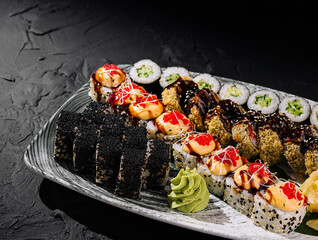 Assorted sushi platter on dark slate background