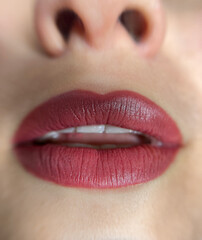 Fototapeta premium permanent makeup on the lips of a young woman of a delicate peach shade close-up, a girl after a cosmetic procedure with smooth and clean healthy skin.