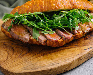 Gourmet croissant sandwich with arugula and ham