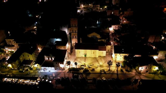 Drone flight over the Church of St. Nicholas in the night city of Perast, Montenegro
