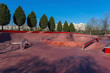 An area built within the park for free skateboarding. Large and small jumping slides are painted red. City Park "Krasnodar" or Galitsky Park. Krasnodar, Russia – April 4, 2024