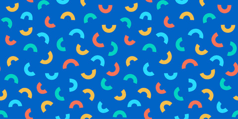 Seamless vector pattern with scattered multicolored shapes on a vivid blue background, fun texture for dynamic designs.