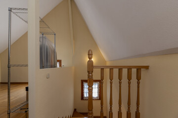 Interior staircase of a single-family home with access to an attic room with oak wood balustrades...