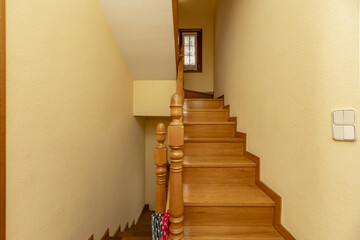 Interior stairs of a single-family home with oak wood balustrades with wooden handrails and steps...