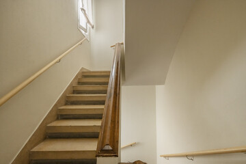 Interior stairs of a single-family home with brick balustrades with wooden handrails and concrete...
