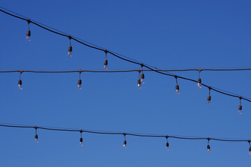 Electric string lights under blue sky