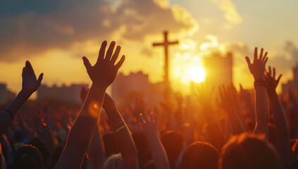 Uplifting scene of hands raised against a sunset at an outdoor event