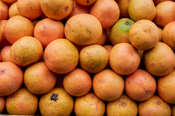 close-up shot of a pile of organic oranges stacked in a greengrocer's store