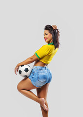 Beautiful young sporty Brazilian woman dressed in sportswear, playing with the ball, soccer and...