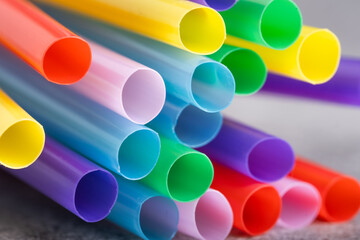 Colored drinking straws on a gray background, closeup.