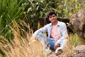 lifestyle: latin peasant sitting in the field surrounded by straw