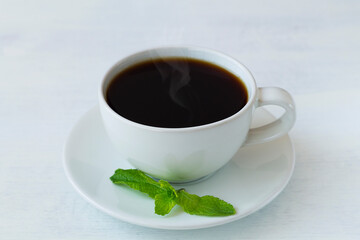 cup of hot black coffee with mint. close-up of white cup of hot Chicory drink or black coffee isolated on a white background. coffee substitute. Copy space.