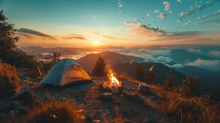 A small tent is set up on a hillside with a fire burning in front of it. The sky is a beautiful orange and pink color, and the mountains in the background are covered in clouds. The scene is peaceful