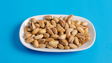 Pistachios bowl isolated on blue
