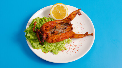 Chicken grill on plate isolated on blue top view