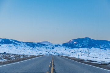 Highway views of  covered Medicine Bow Mountains Range in Colorado at Sunrise