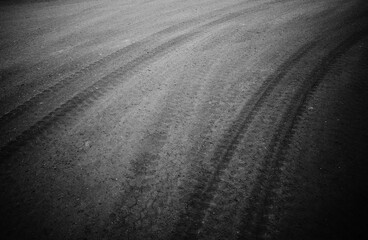 Curved traces of tires on grey asphalt braking distance backdrop