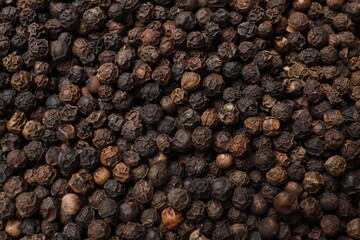 Aromatic spice. Black peppercorns as background, top view