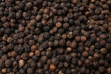 Aromatic spice. Black peppercorns as background, top view
