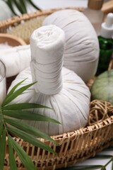 Spa composition with herbal massage bags and cosmetic products on white table