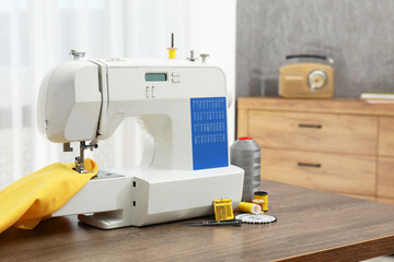 Sewing machine with fabric and craft accessories on wooden table indoors