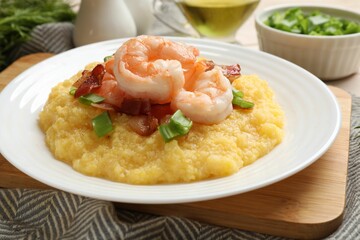 Plate with fresh tasty shrimps, bacon, grits and green onion on table, closeup