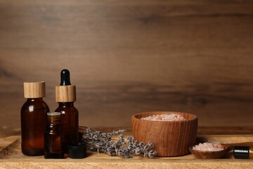 Different aromatherapy products and lavender on wooden table
