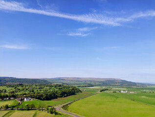 Lawn and mountains in the wild fields of Stirling, Scotland, UK, with blue sky and white clouds