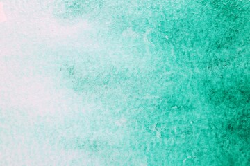 Abstract green watercolor painting on white paper, top view