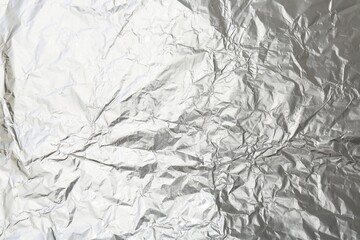 Crumpled silver foil as background, top view