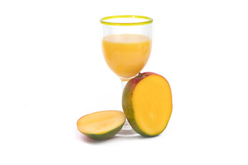 a cut mango with a glass of mango juice beverage isolated on white
