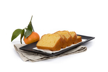 slices of orange loaf cake on a black tray with a leaf orange in the background isolated on white